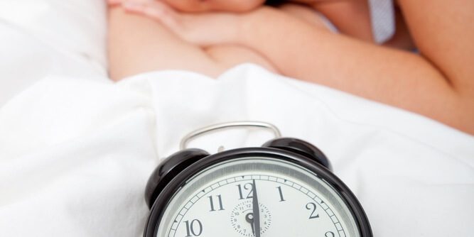 sleeping person with a timer on their bed