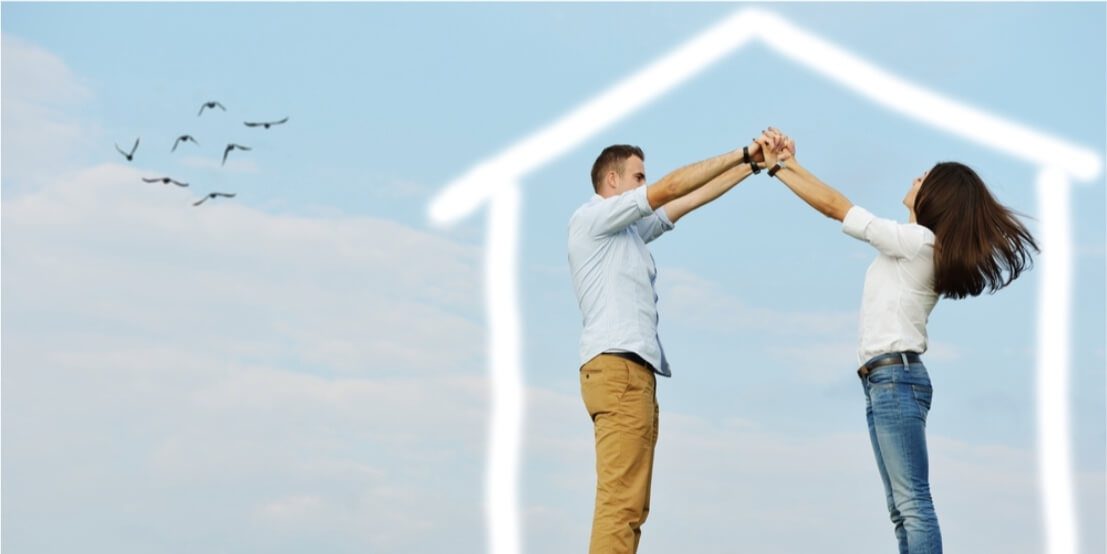 couple holding hands with a drawing shaped of house