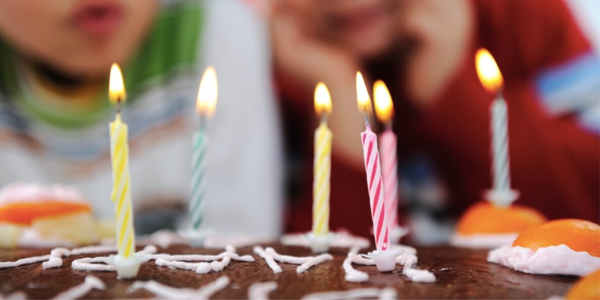 kids blowing candles on cake
