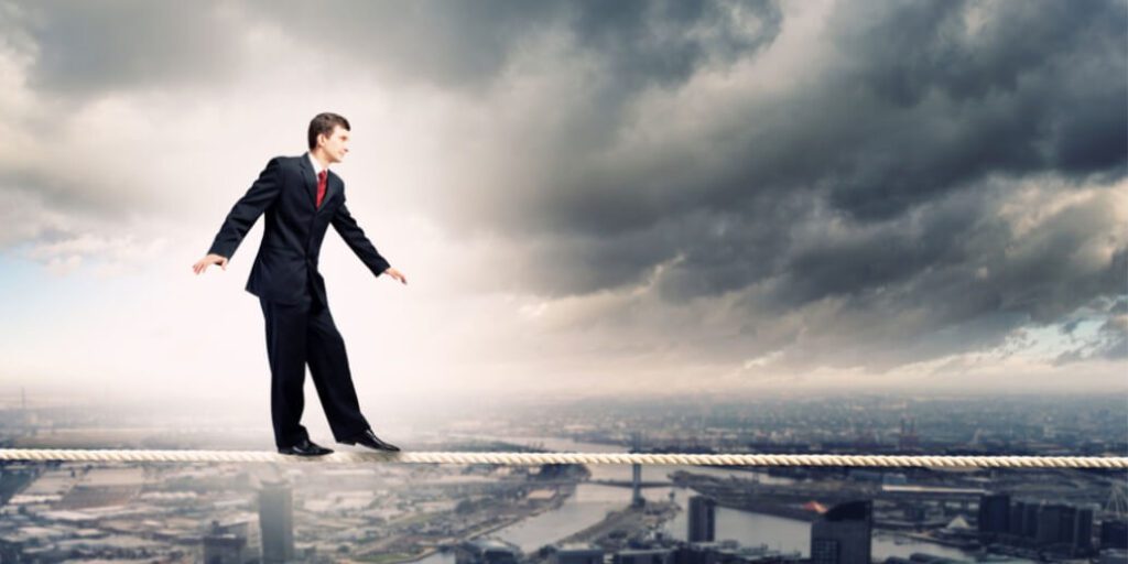 a businessman walking on thin rope