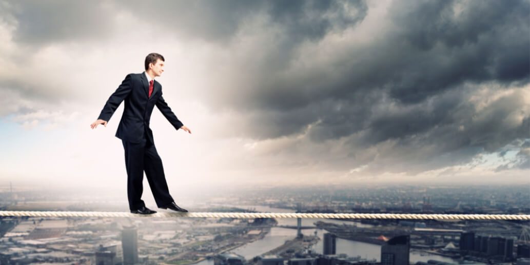 a businessman walking on thin rope