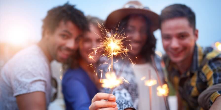 group of friends holding a sparkling candle
