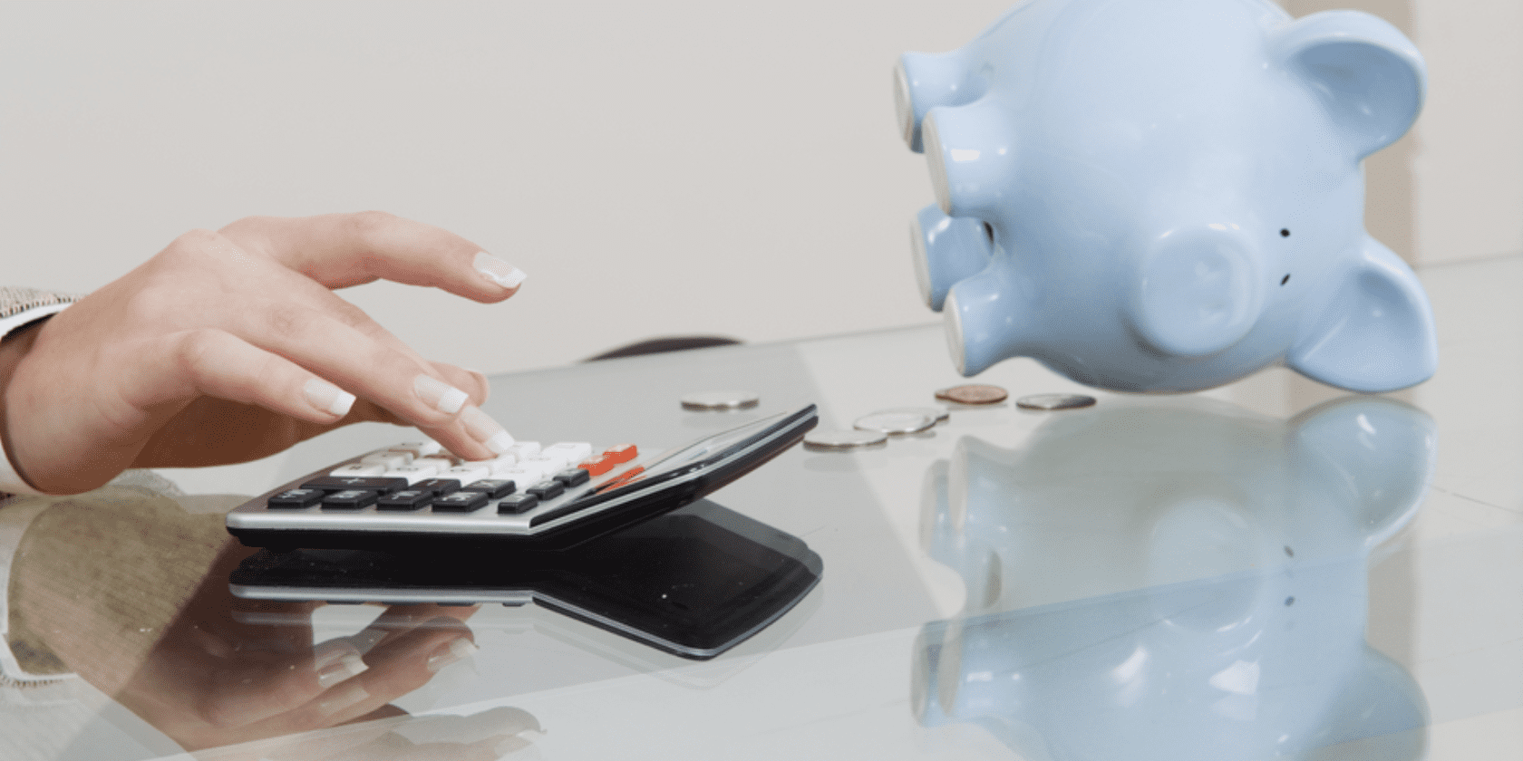 a image of hand doing a calculator with blue piggybank